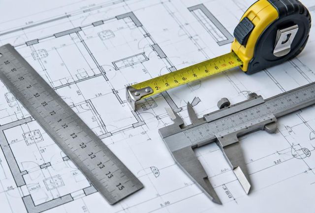 Ruler, calipers and tape measure on architectural plans